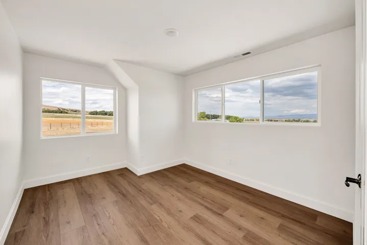 Recessed lighting and wood-finish flooring complement the white walls