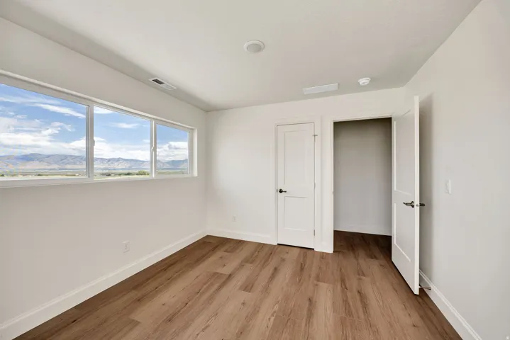 Three-pane window with mountain scenery, wood-finish flooring, two panel doors, and recessed ceiling lighting
