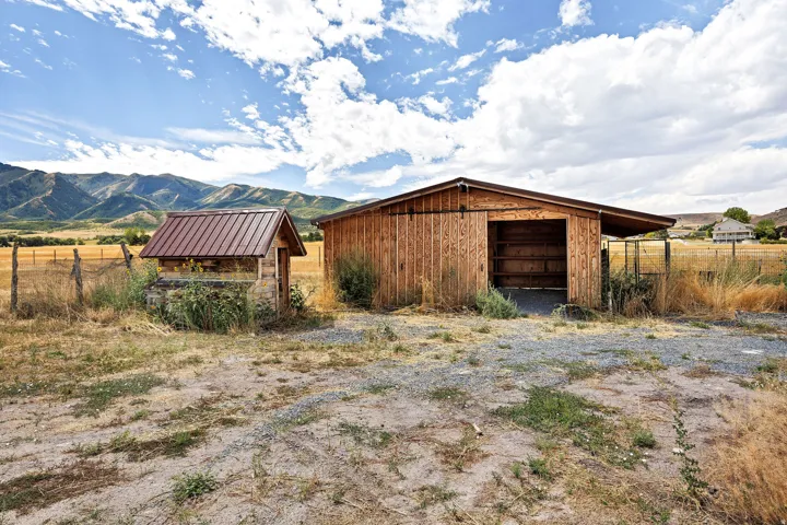 Wood-clad outbuilding with an open bay