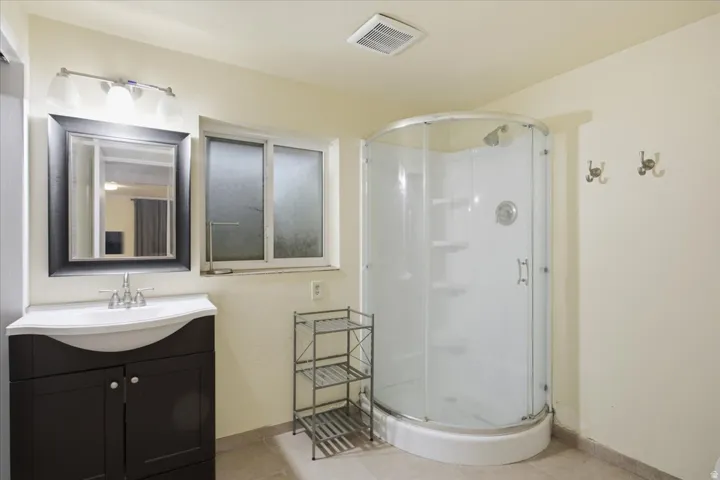Dark wood-finish vanity with white integrated sink, chrome faucet, and framed mirror