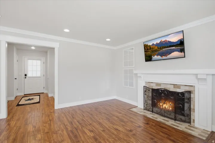 Wood-finish flooring, recessed lighting, and crown molding