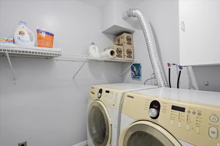 Utility space featuring wire shelving and wall-mounted cabinetry