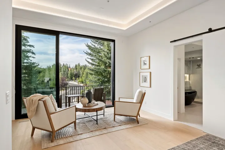 Full-height glass sliding doors open to a private balcony with metal railings