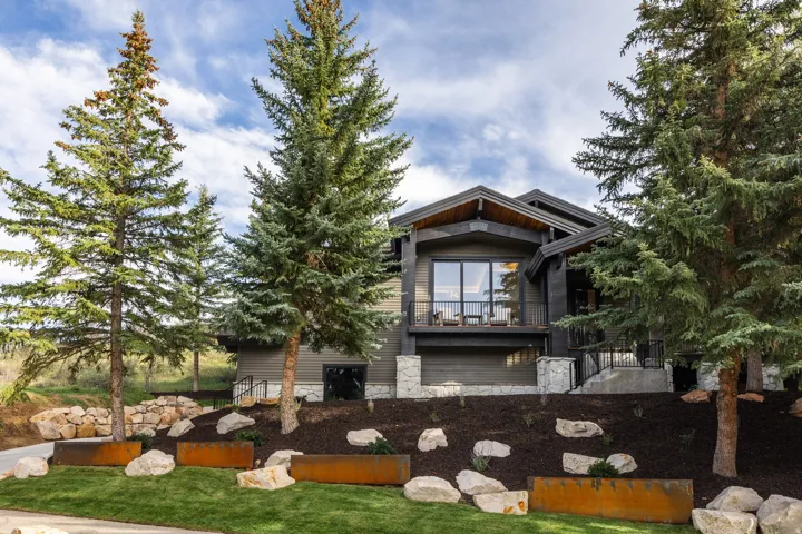 Contemporary exterior with dark siding, stone accents, and a large balcony