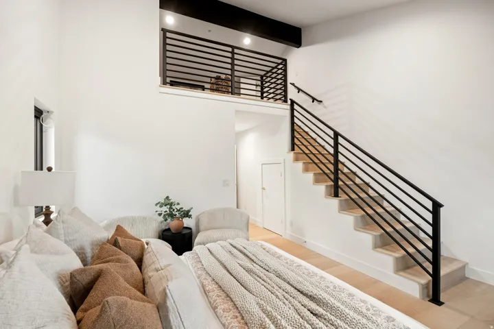 Vaulted ceilings, a built-in loft, wood-finish flooring, and a contemporary railing system with horizontal balusters