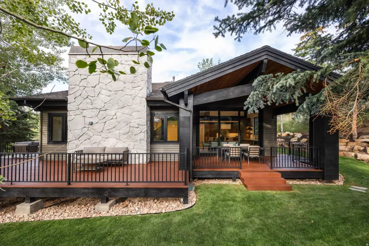 Expansive outdoor deck with black railings and a stone-clad chimney