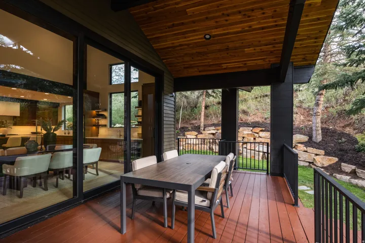 Expansive covered deck with wood plank flooring and a wood-paneled ceiling