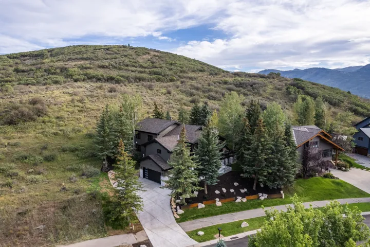 Contemporary residence with dark-toned exterior siding, an attached garage, and a concrete driveway