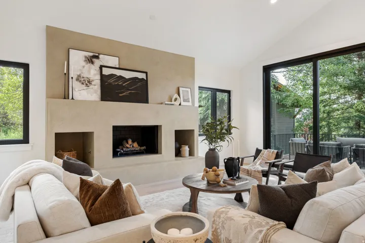 Vaulted ceilings, a built-in fireplace with hearth, and dark-framed windows