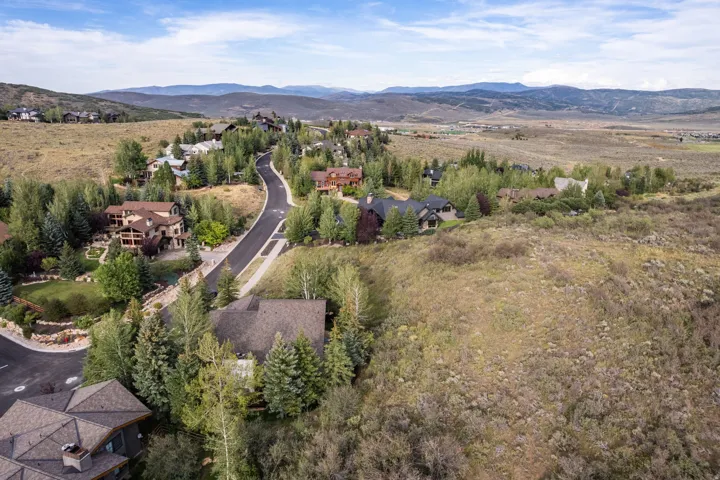 Mountainous terrain with residential properties situated along a paved road
