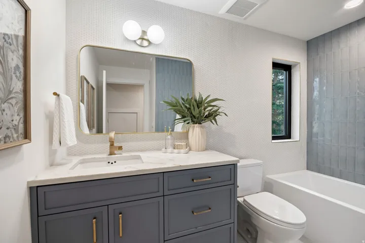Vanity with stone countertop, integrated sink, and gold-finish fixtures