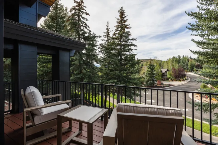 Outdoor balcony with wood-finish flooring and black metal railing