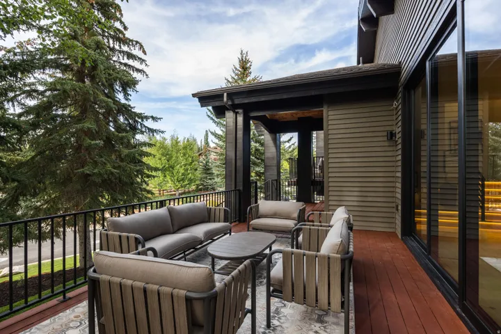 Expansive outdoor deck featuring wood-finish flooring, a black metal railing, and horizontal siding