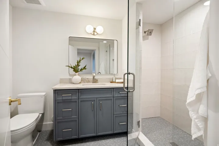 Glass-enclosed shower with tiled walls and floor