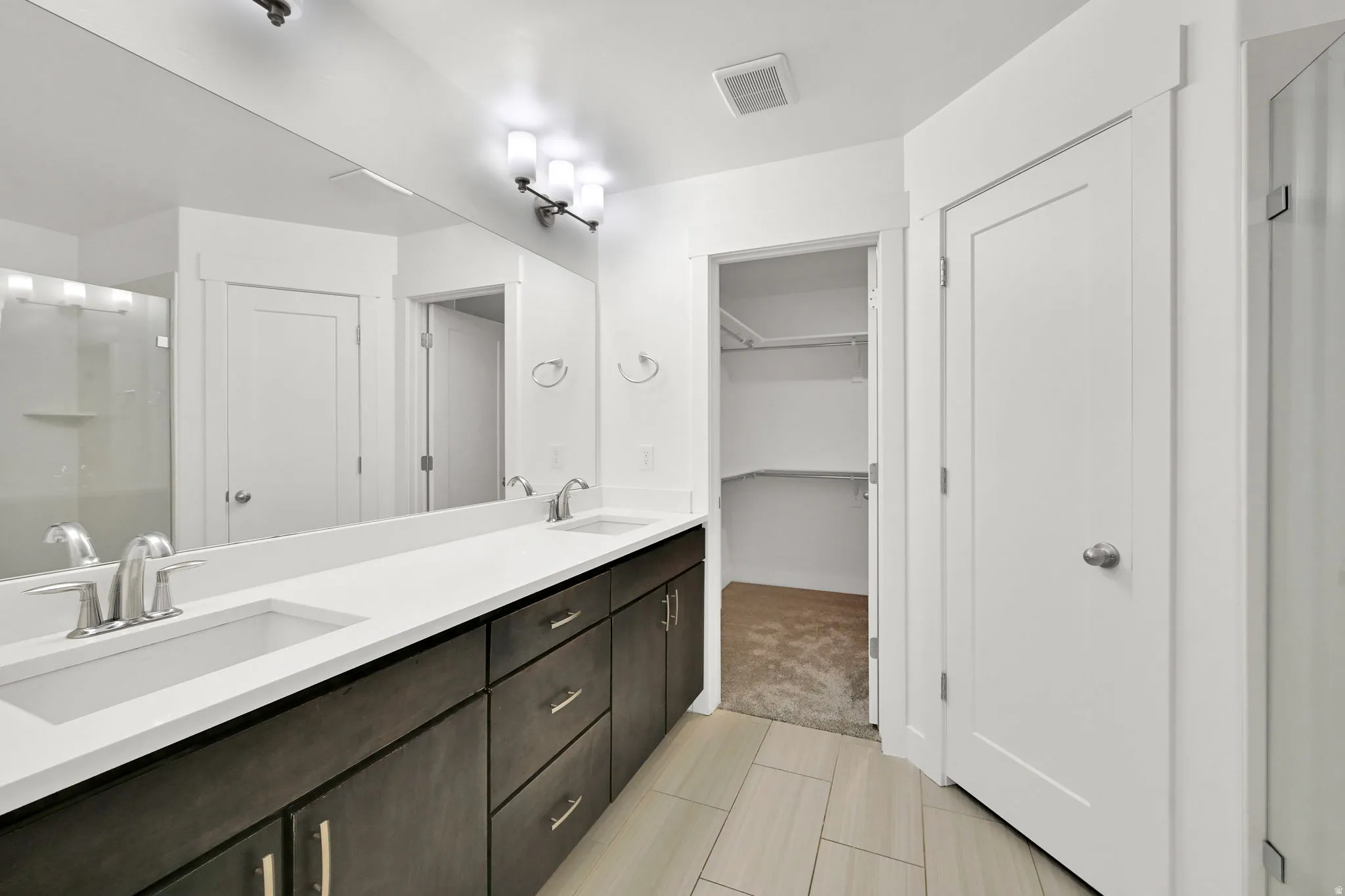 Dual vanity with undermount sinks, expansive mirror, and integrated lighting