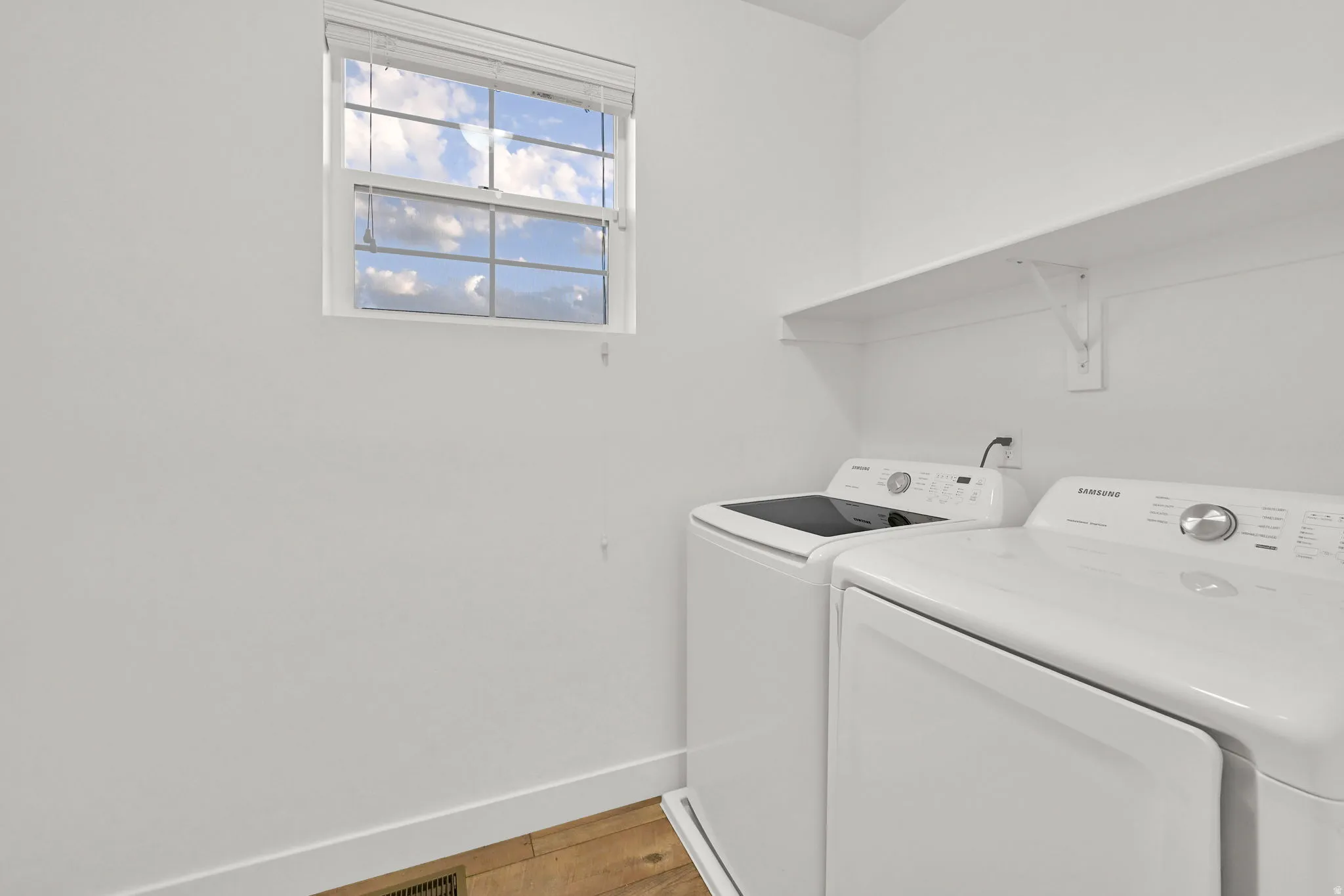 Utility area with built-in shelving and wood-finish flooring