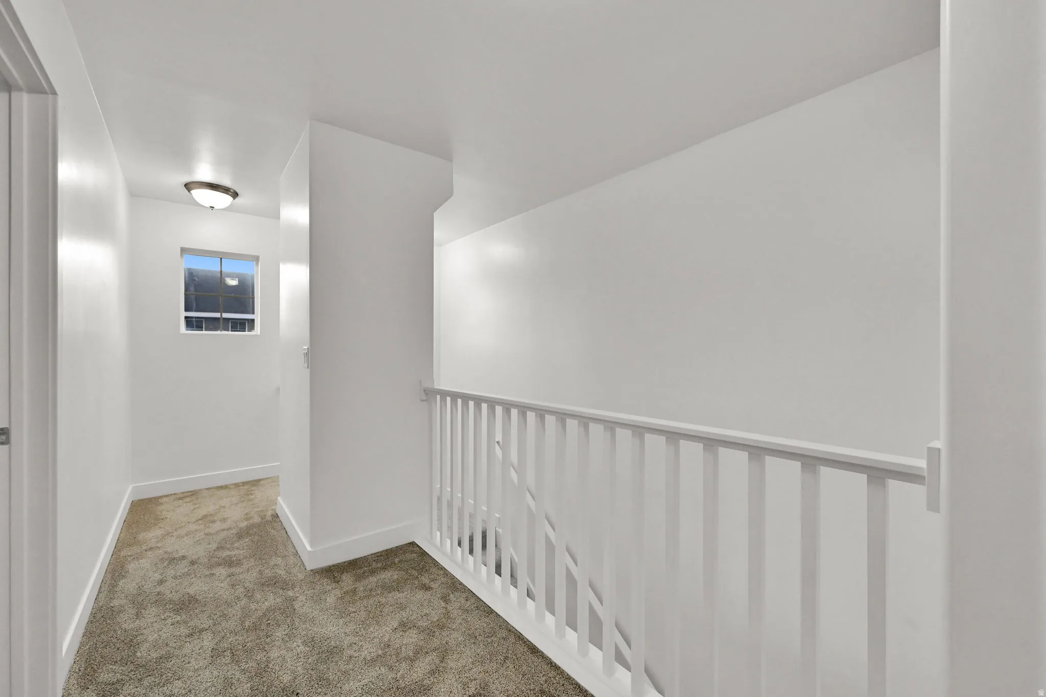 White painted walls, carpeted flooring, window with natural light, and a flush-mount ceiling light fixture