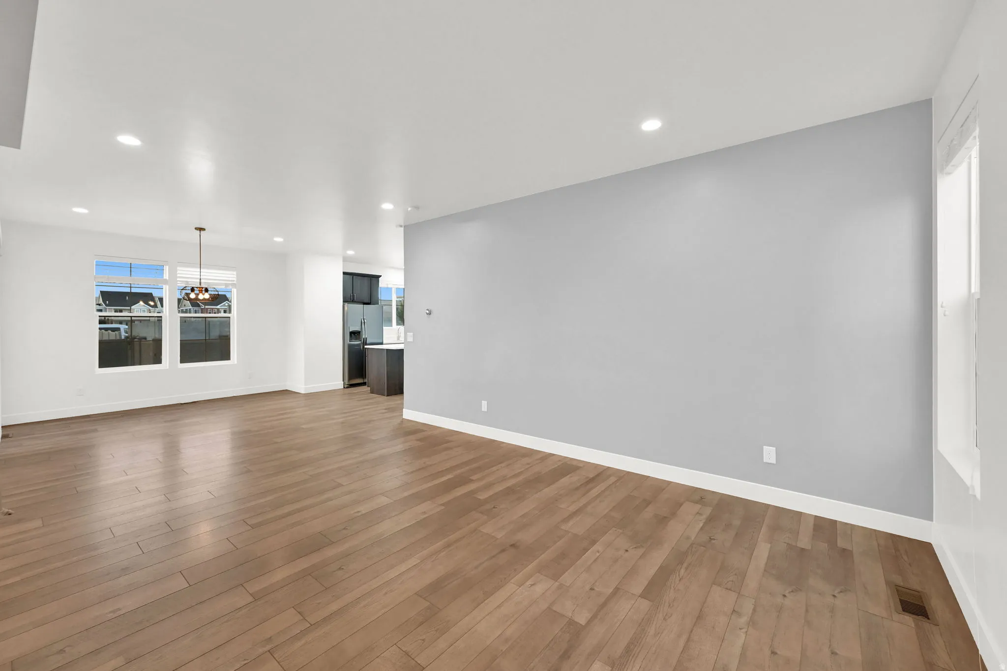 Recessed lighting, wood-finish flooring, and white trim