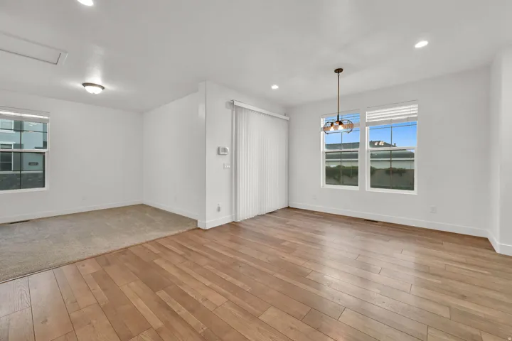 Wood-finish flooring, recessed lighting, and large windows with blinds