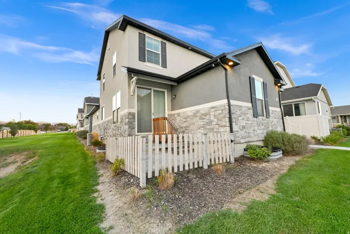 Two-story exterior with a stone and stucco facade, a private deck, and a sliding glass door