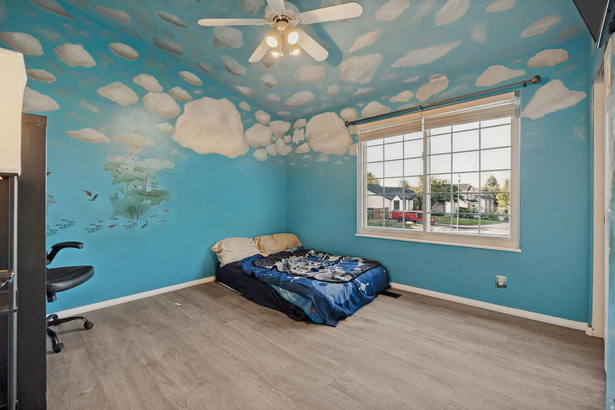 Wood-finish flooring, ceiling fan, and large window with blinds