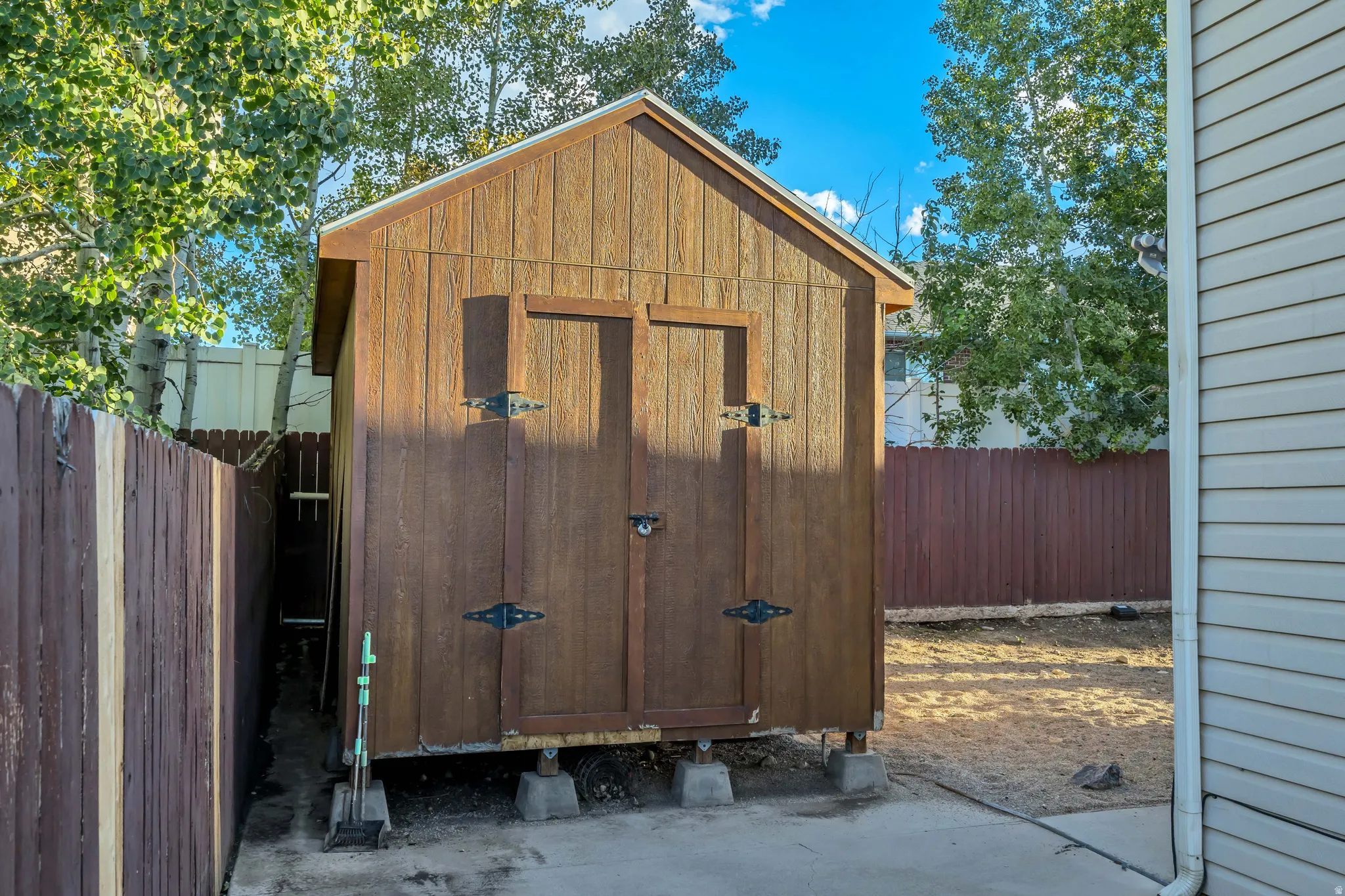 Wood-sided shed with dual doors and visible foundation blocks