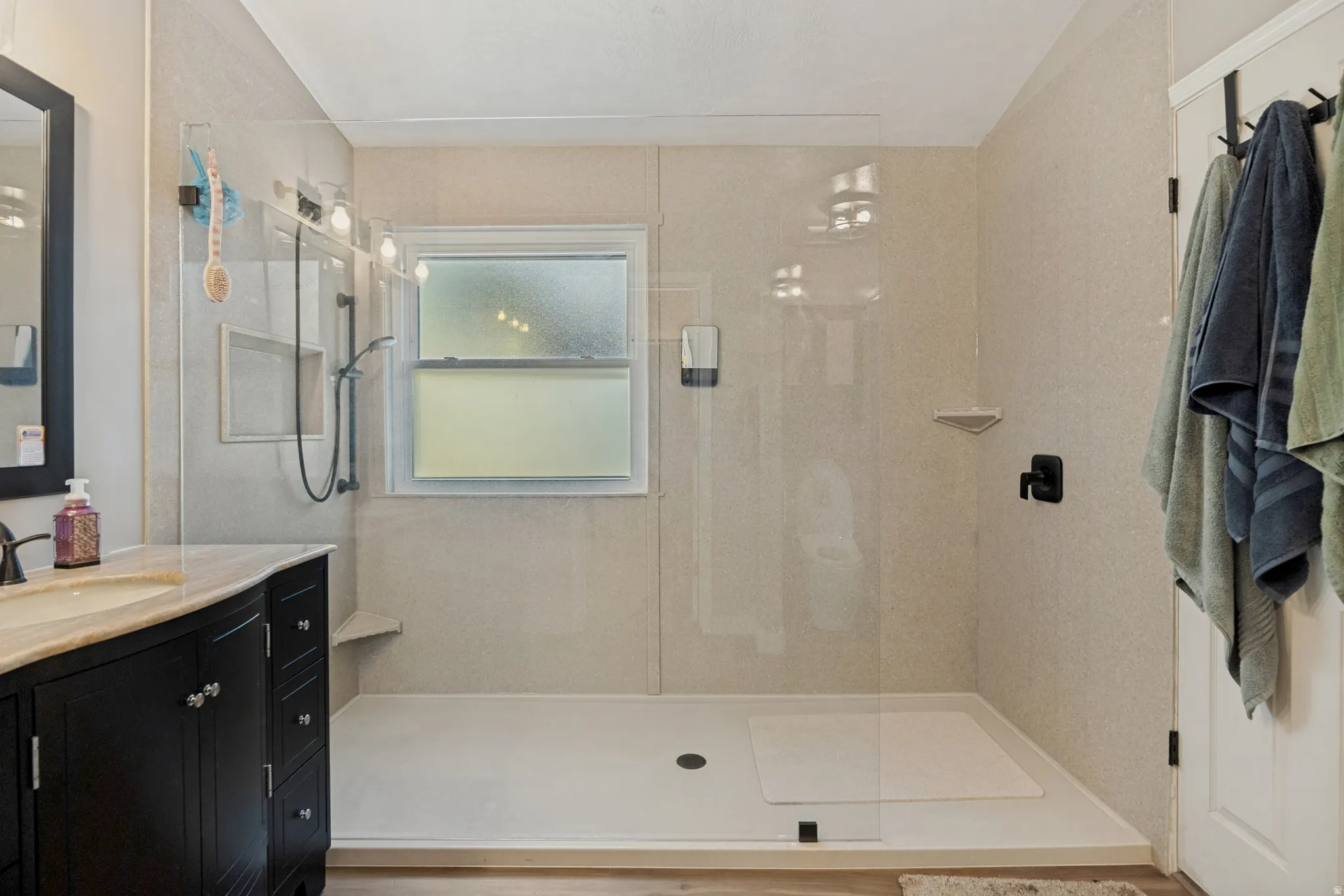Walk-in shower with clear glass enclosure and built-in shelving