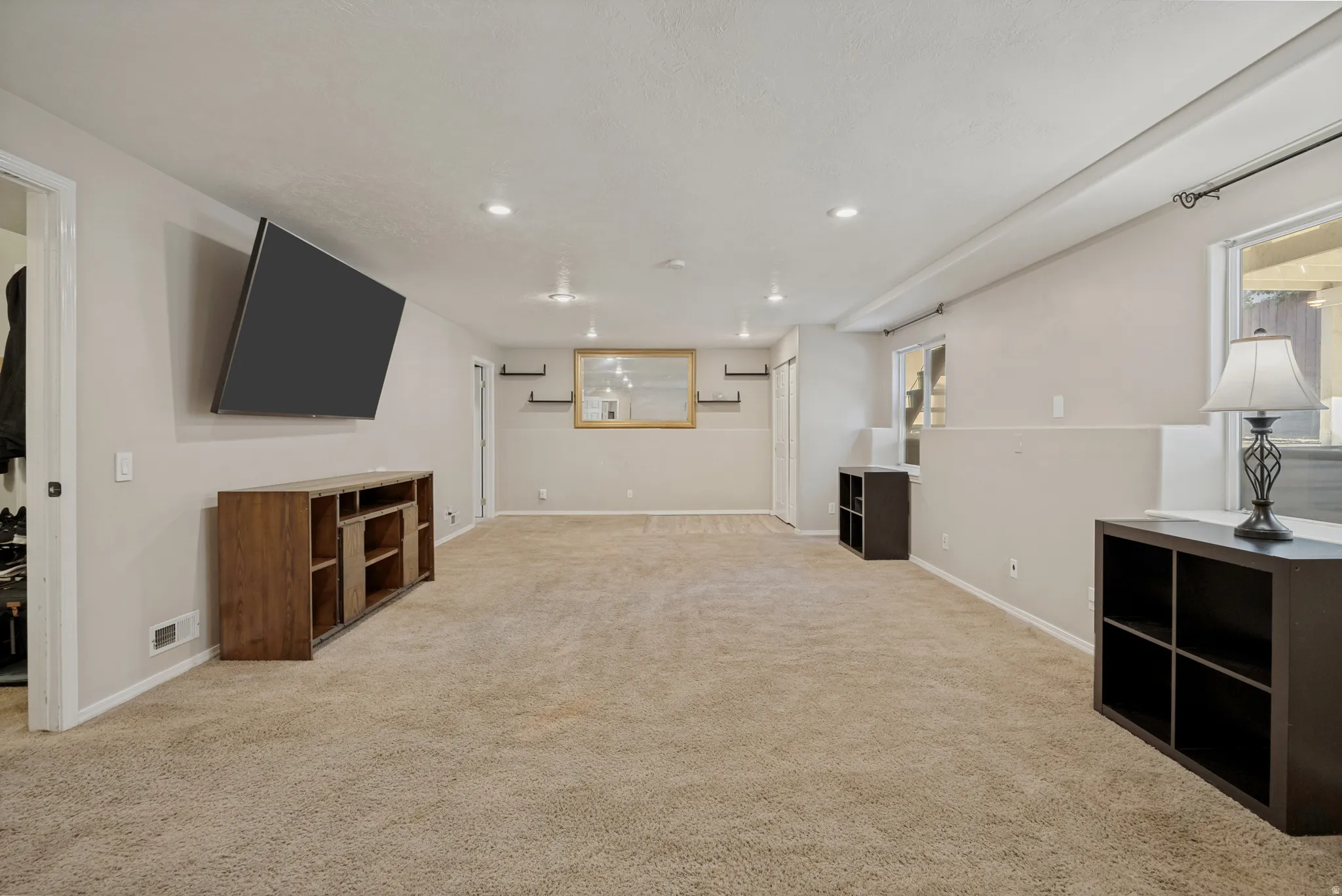 Recessed lighting, light-toned carpeting, and neutral wall tones