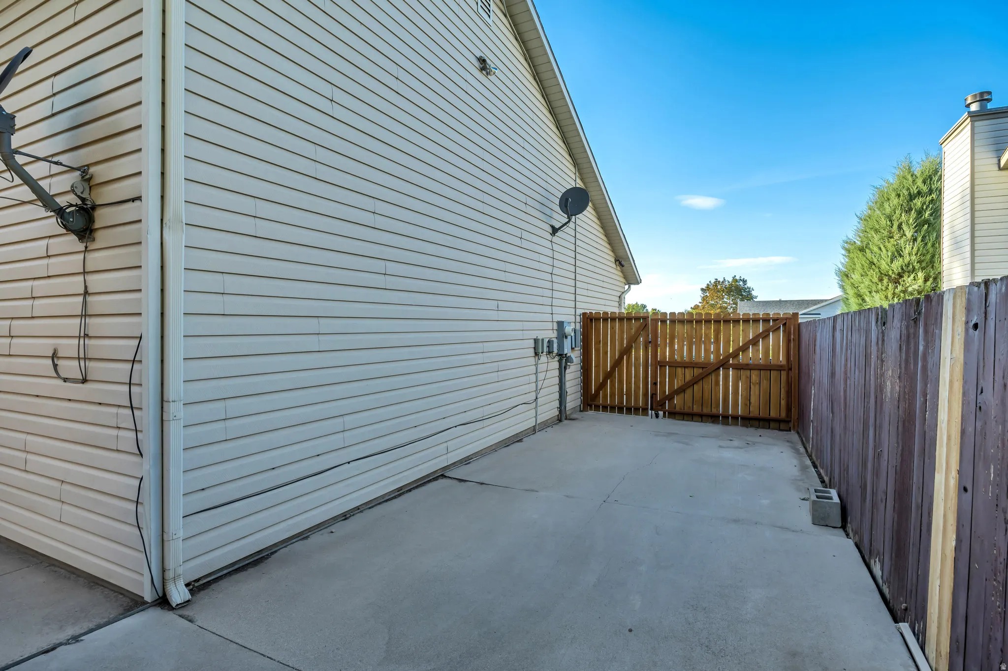 Concrete pad, wood privacy fence, wood gate, vinyl siding