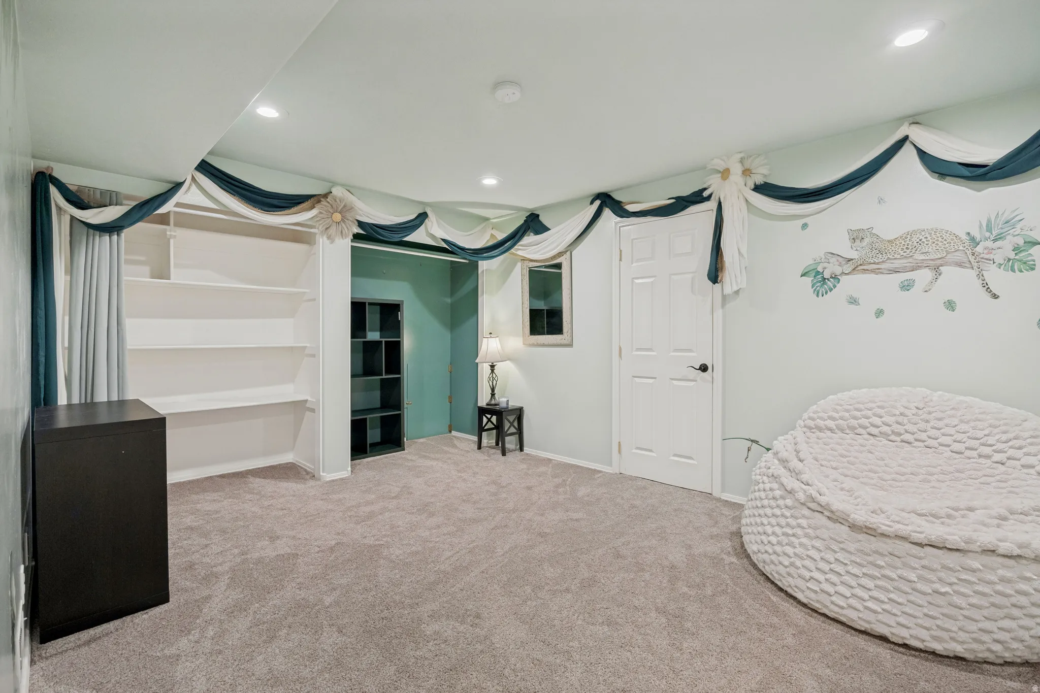 Recessed ceiling lighting, built-in shelving, and carpet flooring