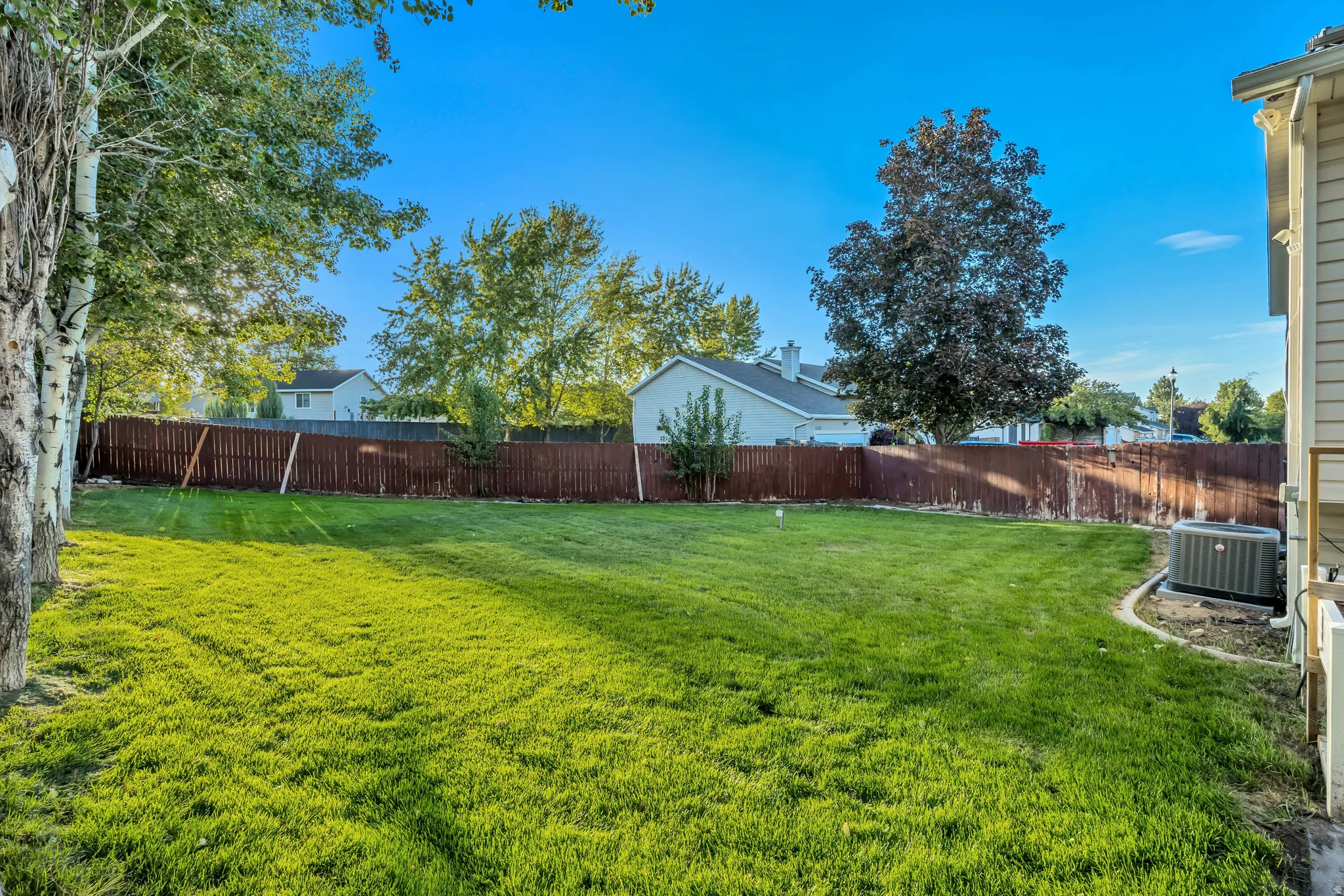 Expansive lawn area with a wood privacy fence
