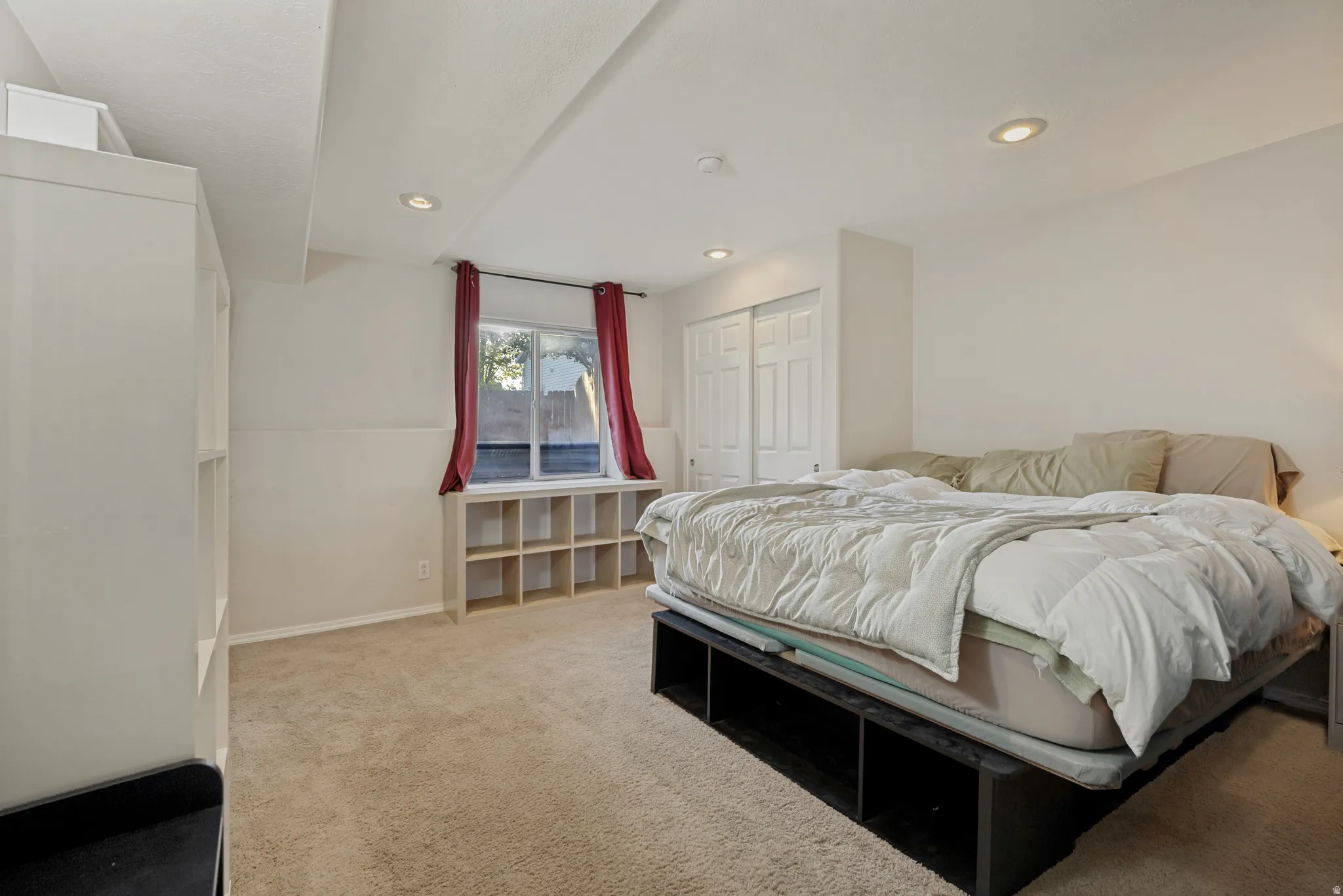 Recessed lighting, built-in shelving, window with built-in storage, and sliding closet doors
