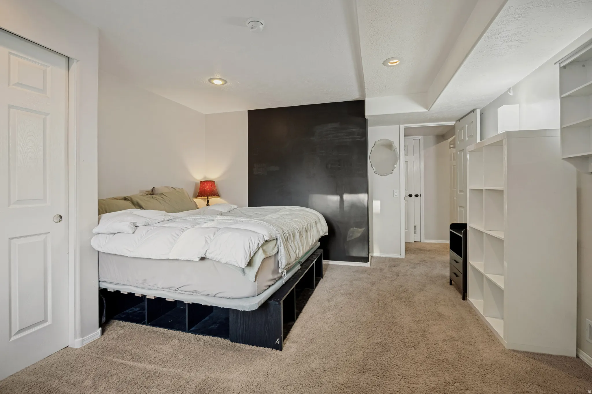 Recessed ceiling lighting, textured wall finish, and built-in shelving units
