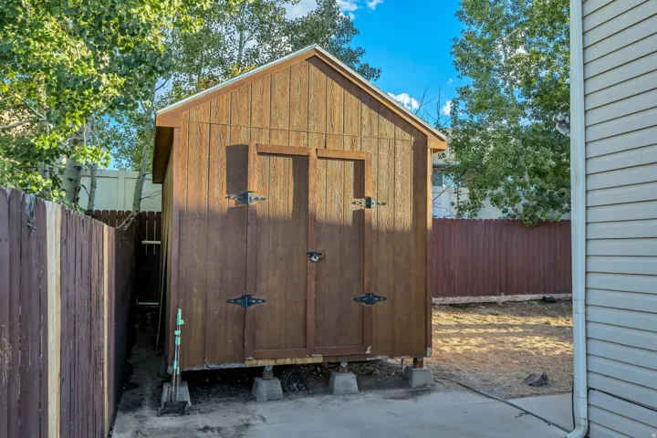 Wood-sided shed with dual doors and visible foundation blocks