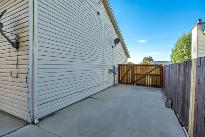 Concrete pad, wood privacy fence, wood gate, vinyl siding