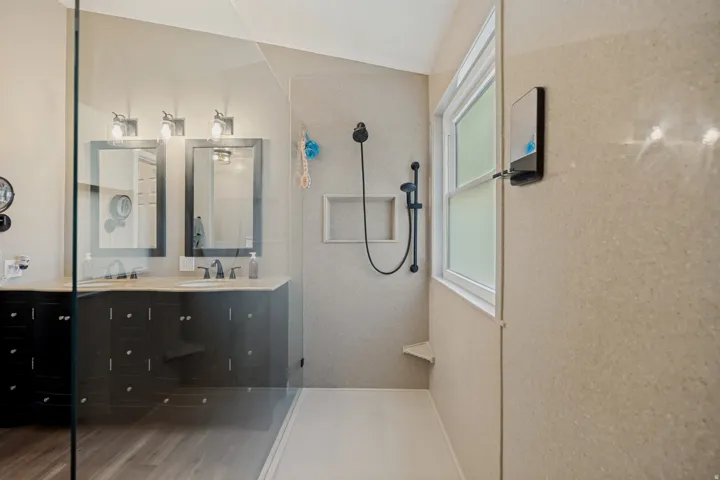 Glass-enclosed shower with a built-in niche and corner bench