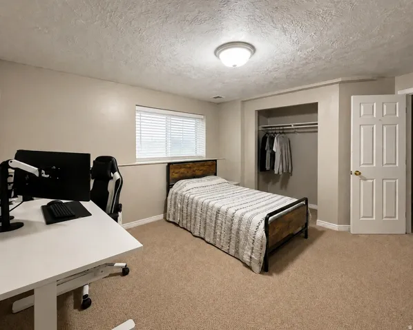 Neutral-toned walls, carpeted flooring, and a window with blinds