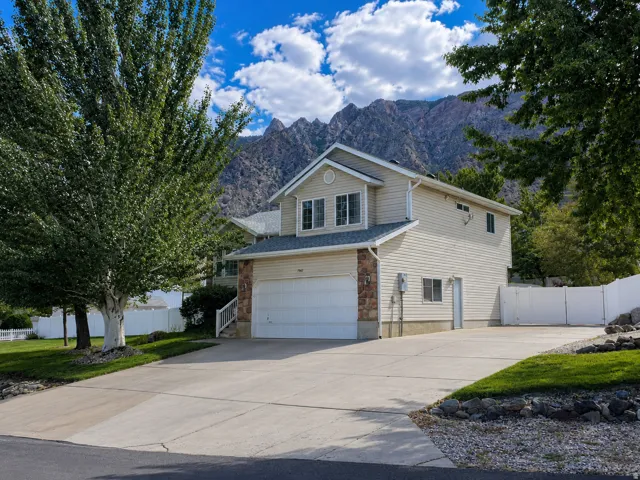 Exterior featuring light-colored siding, stone accents, and a two-car garage