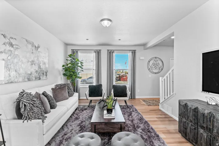 Light-toned wood-finish flooring, recessed lighting, and white wall finishes