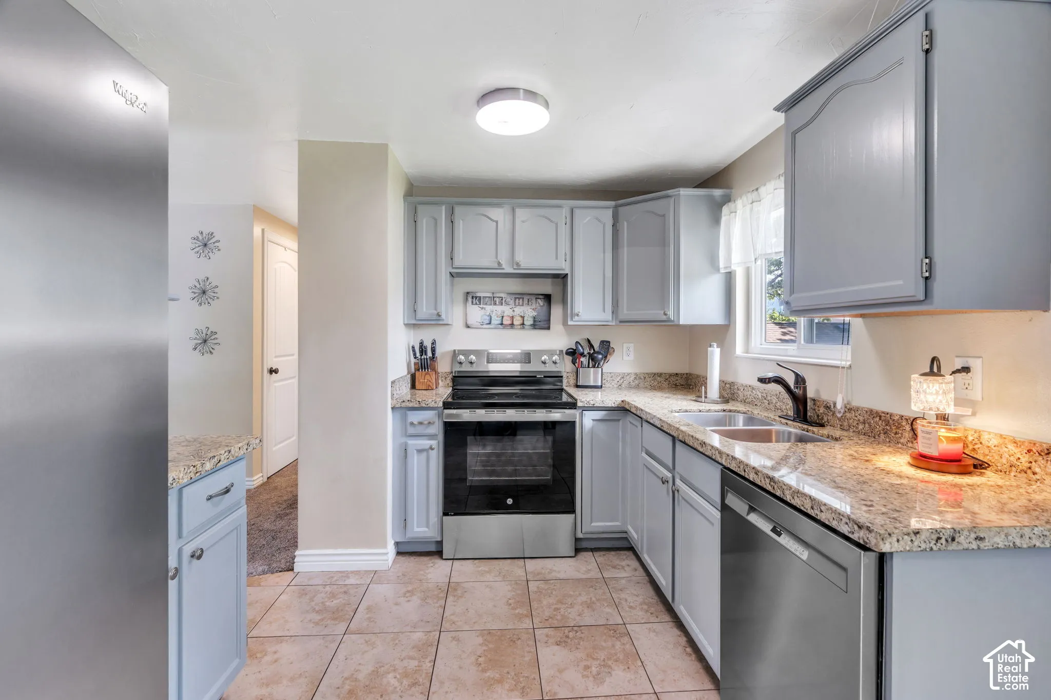 Refreshed kitchen featuring gray painted cabinetry, granite countertops and updated appliances.