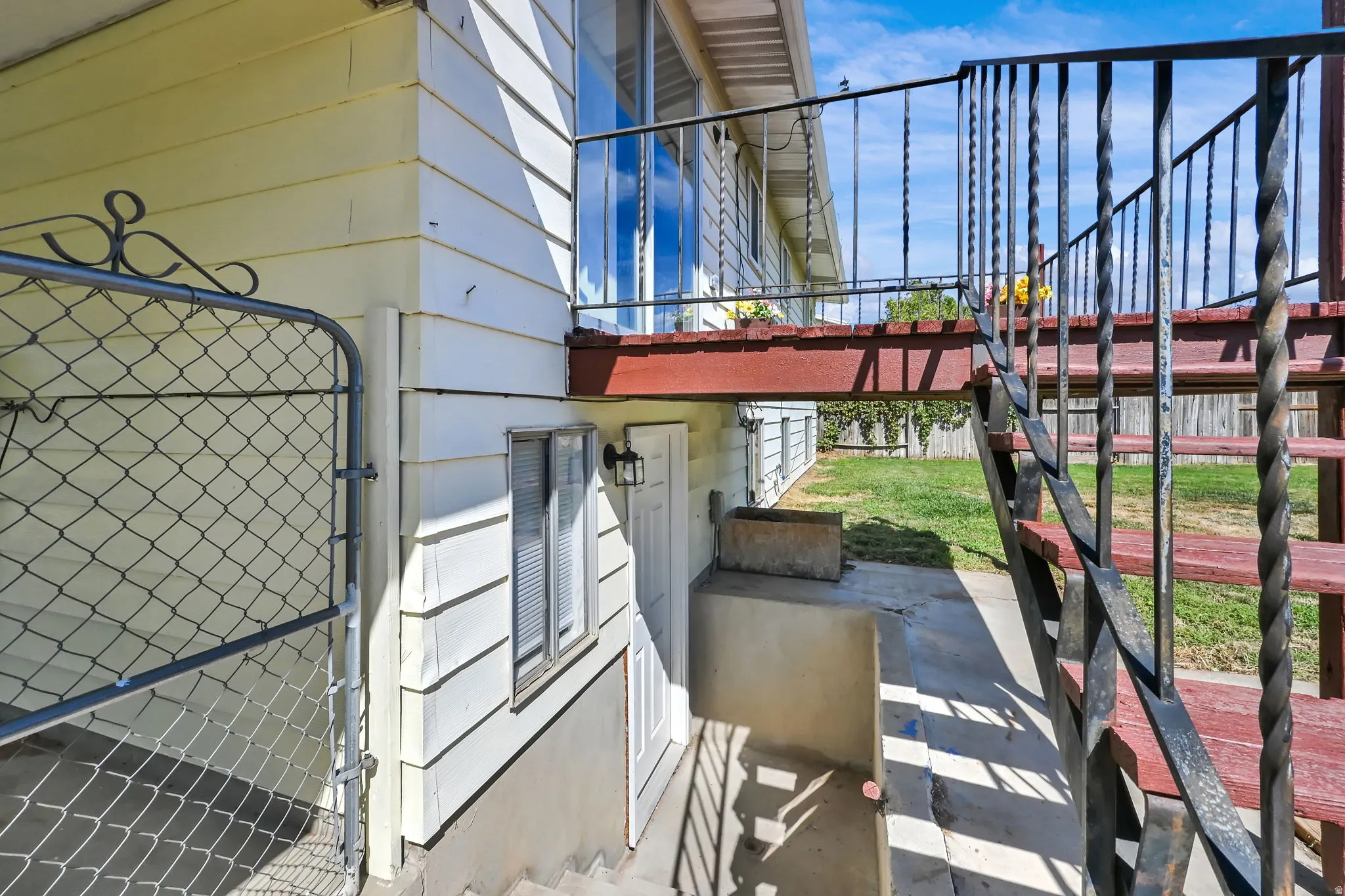 Exterior featuring horizontal siding, a red-painted deck, and wrought iron railings