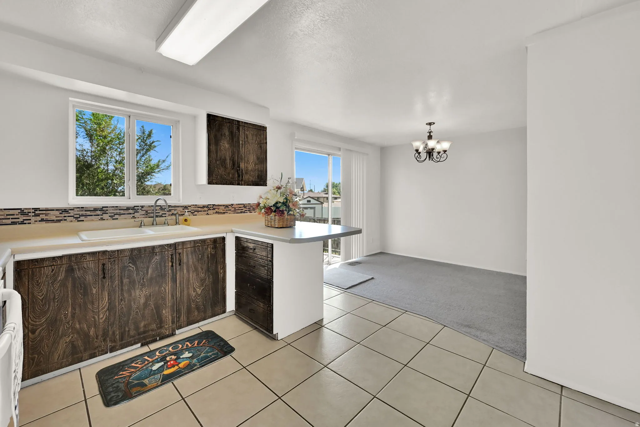 Kitchen with wood-finish cabinetry, tile flooring, and a breakfast bar