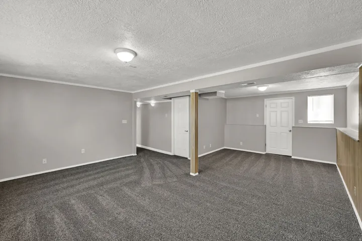 Carpeted room with light grey walls, white trim, and flush mount ceiling lights