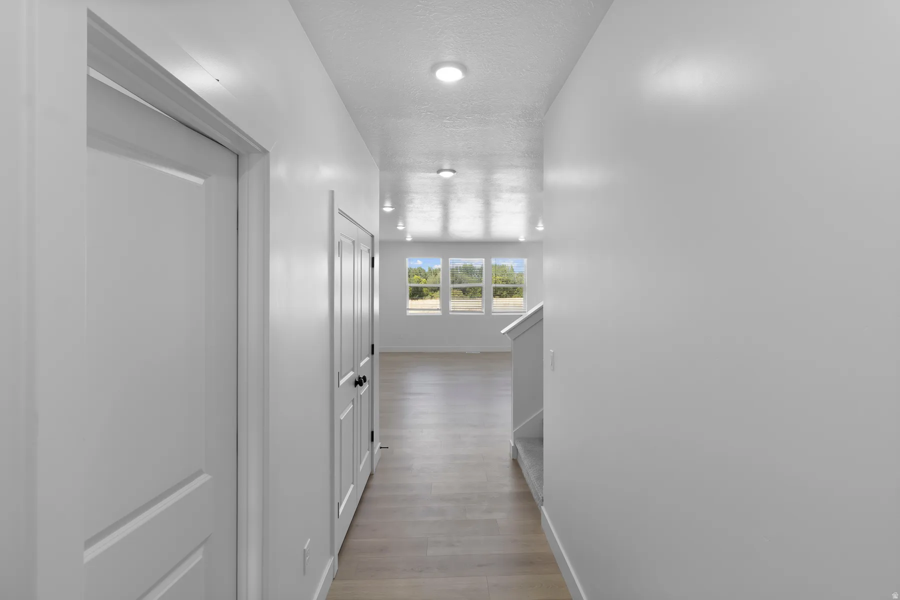 Recessed lighting illuminates wood-finish flooring