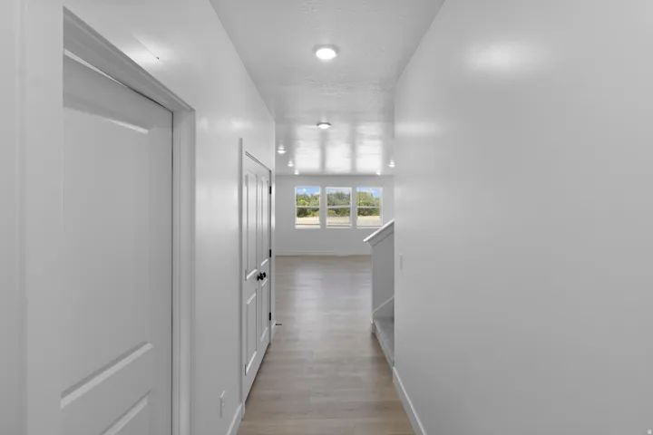 Recessed lighting illuminates wood-finish flooring