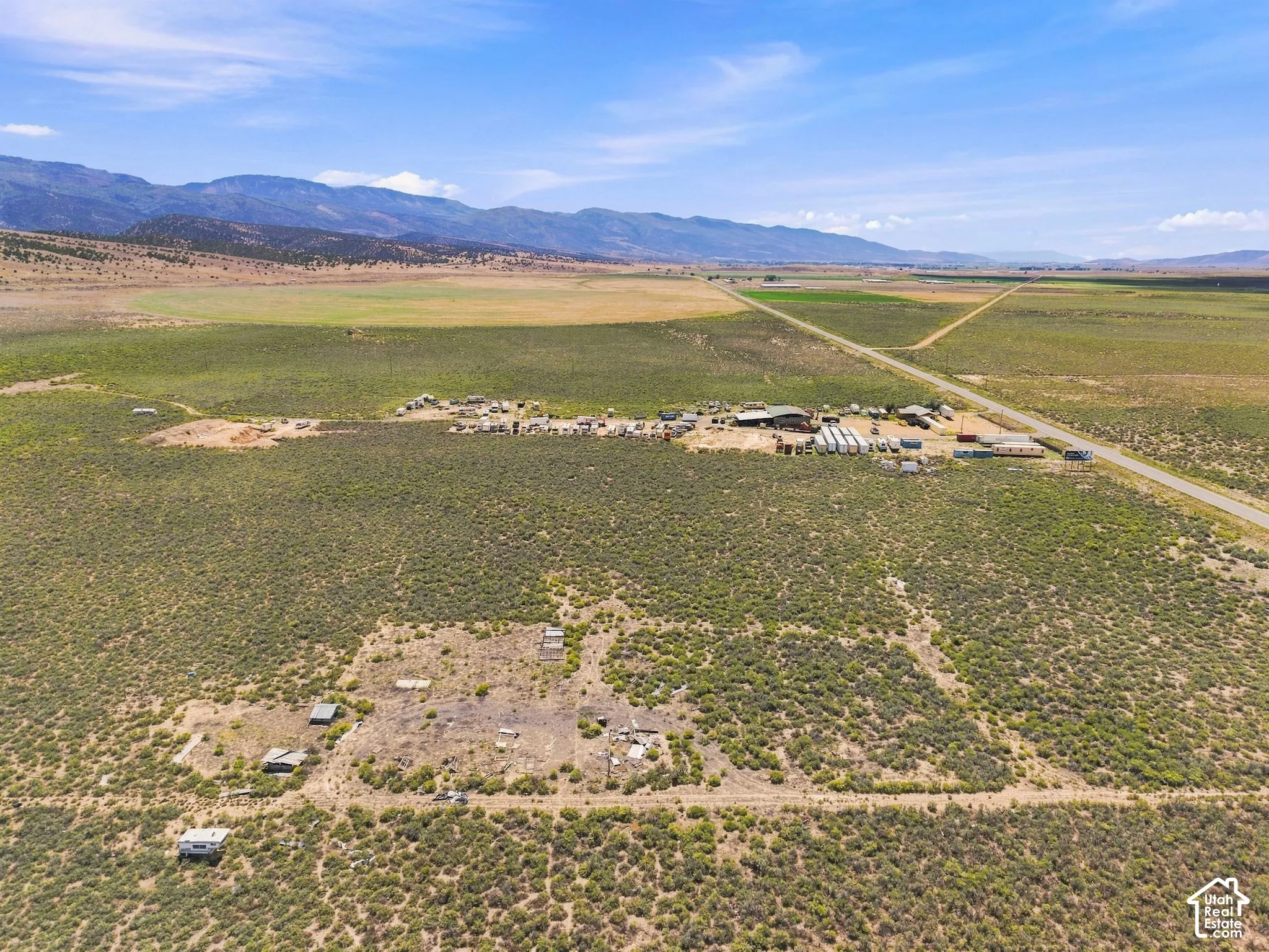Expansive rural landscape featuring a central building cluster and a road network