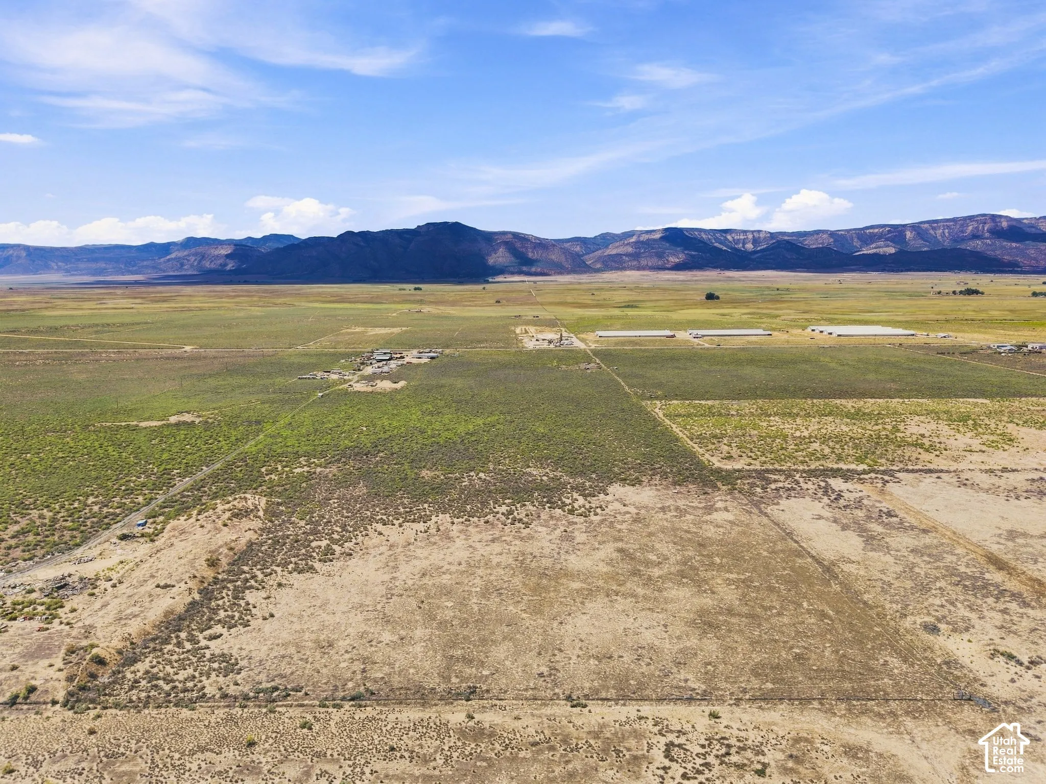 Expansive rural property featuring varied vegetation and distant mountain ranges
