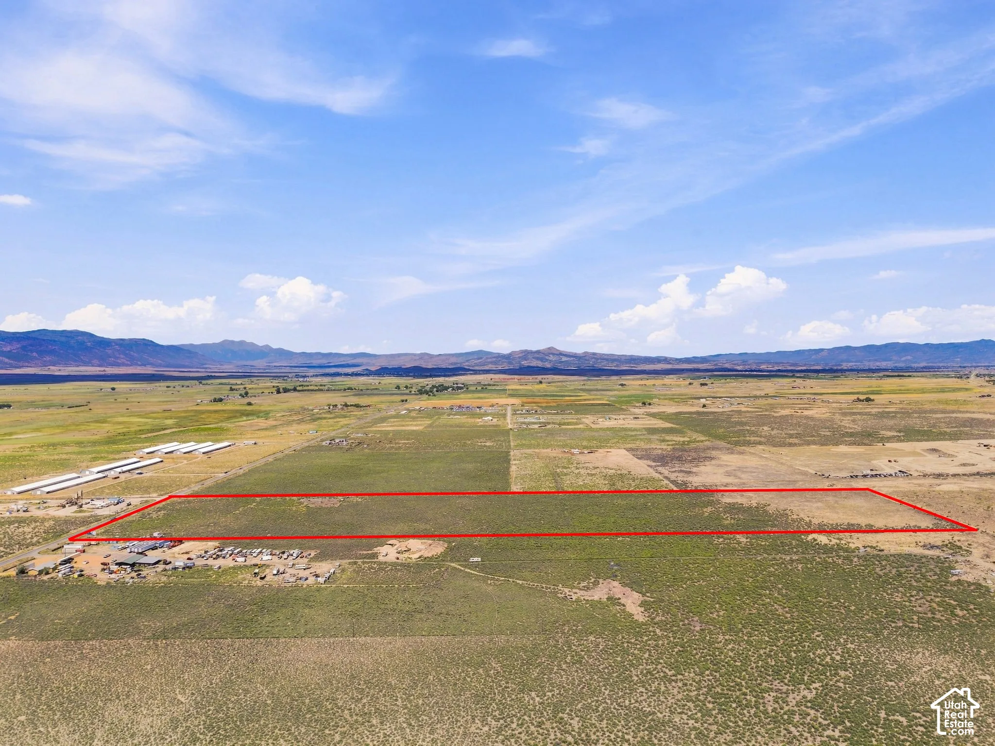 Expansive land parcel featuring open fields and distant mountain ranges