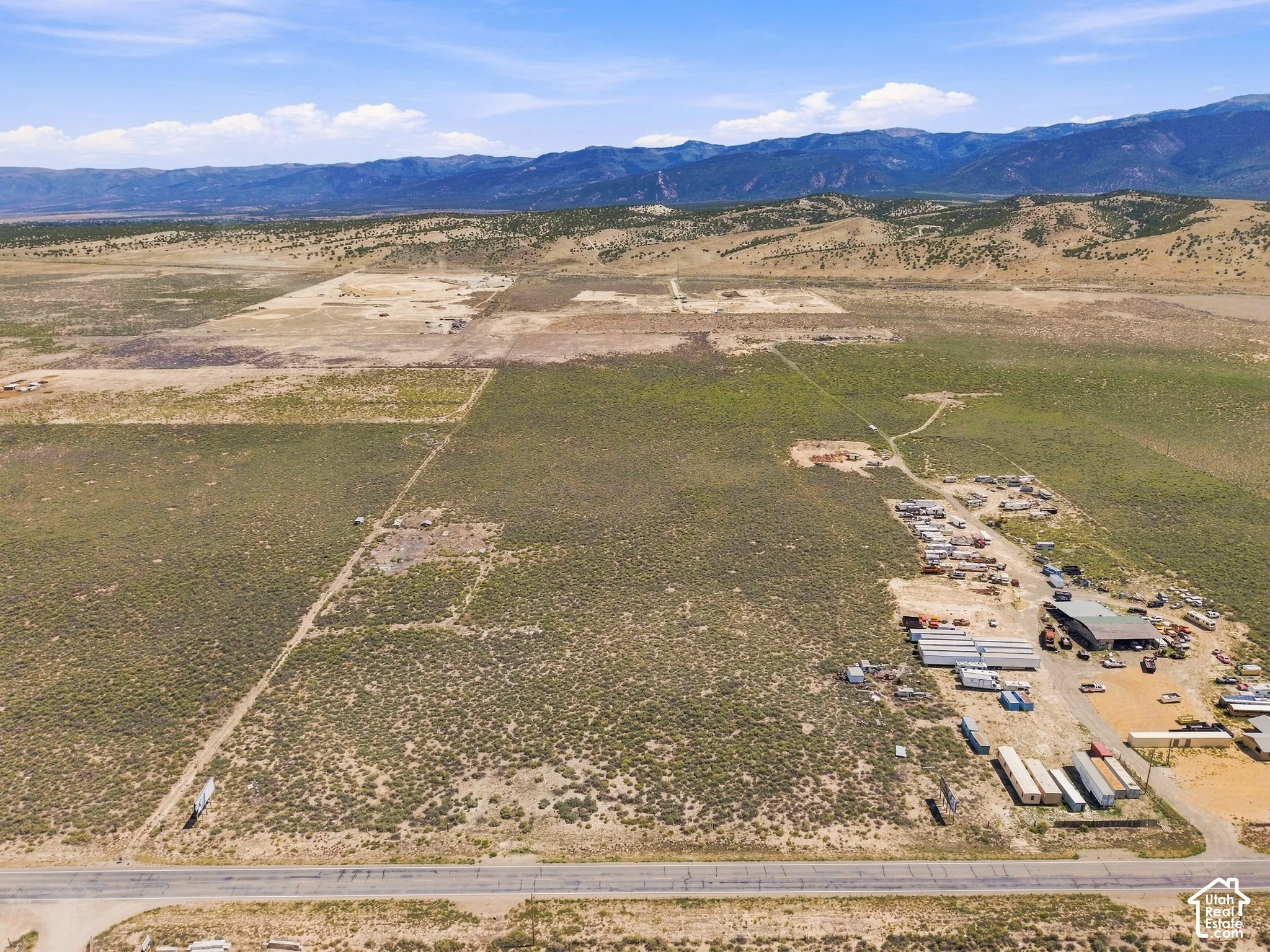 Expansive undeveloped land with visible utility lines and mountain backdrop