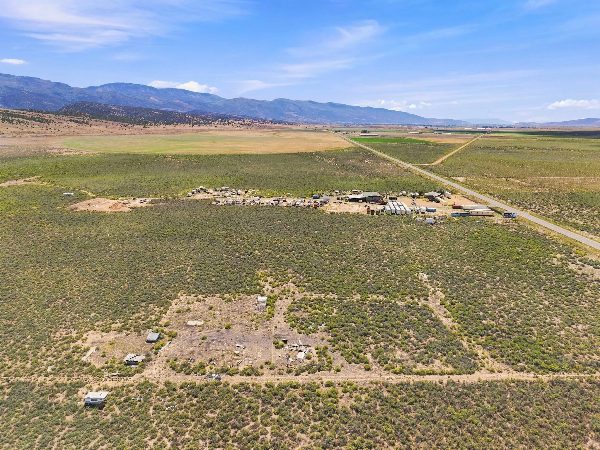 Expansive rural landscape featuring a central building cluster and a road network